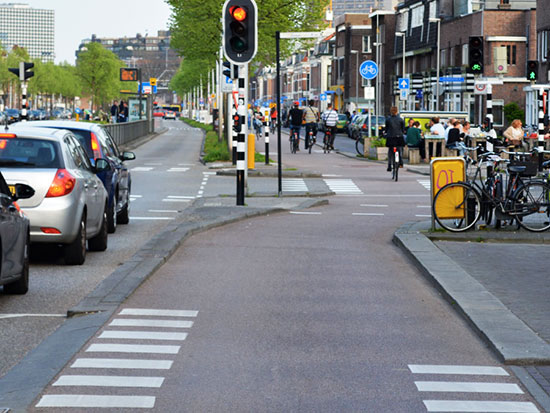 A cycleway changes from regular cycleway height down to carriageway level at the main junction ahead, but the change is so smooth that it is almost imperceptible.