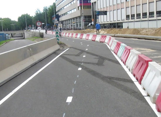 A temporary cycleway. Wide two-way cycleway separated from motor vehicles by heavy barriers.