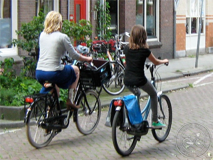 A mother and her young daughter ride their bikes